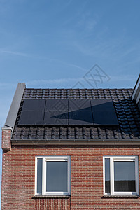 在阳光明媚的天空下 屋顶上附有太阳能电池板的新建房屋特写带有黑色太阳能电池板的新建筑 翻译 太阳能电池板 太阳能生态住宅能源太阳图片