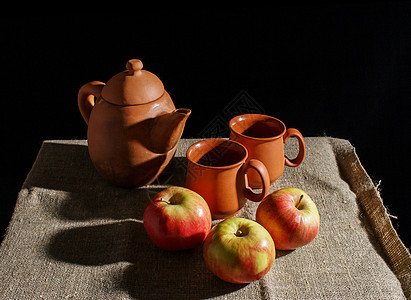 活在泥土茶壶中 两个杯子和三个红苹果之下陶瓷红色生活黏土棕色文化制品陶器黑色服务图片