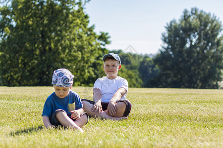 开朗的孩子们 两兄弟 开心地笑着 我们很高兴在温暖晴朗的天气里在公园的草坪上散步和玩耍 孩子们的情绪在脸上衬衫童年青年儿子生活金图片