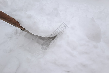 冬天暴风雪过后用铲子扫雪图片