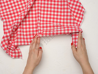 两只女性手在白桌上 拿着一块压碎的白红白色餐巾纸桌子正方形厨房抹布材料空白检查食物织物野餐图片