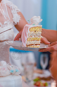 新娘把婚礼蛋糕的一块放在盘子里传给客人图片