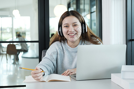 使用计算机和移动设备在线学习的年轻拼图学生 笑声教科书商业阅读教育技术通讯写作考试笔记本图书馆图片