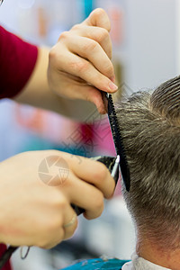 理发师用剪刀和梳子把男士的头发剪了 短发图片