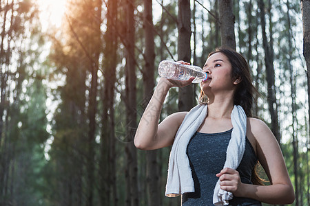 美丽的年轻女子健身后饮用饮水水瓶体能锻炼公园女孩运动员女性瓶子训练口渴赛跑者女士森林图片