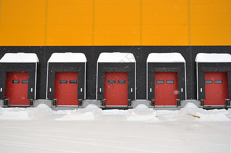 一个大型仓库的空卸货区冬季充斥着雪雨坡道运输分隔器时间货物条件加载降雪黄色入口图片