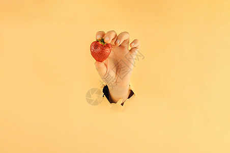 女孩用手指握着红色的成熟草莓 撕破纸上的女人手拿着果汁 网上购物概念店铺营销饮食浆果购物商业市场团体顾客销售图片