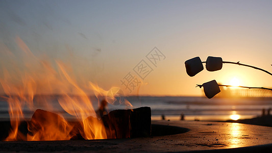 美国加利福尼亚州的篝火坑 在海洋海滩上营火 在篝火上烤吐司棉花糖气氛火焰烧烤支撑波浪燃烧日落海景海岸海洋图片