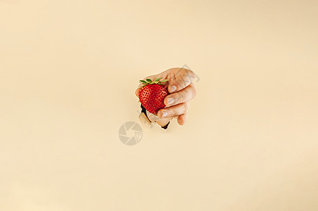 女孩用手指握着红色的成熟草莓 撕破纸上的女人手拿着果汁 网上购物概念农业店铺美食篮子大车购物车市场浆果购物食物图片