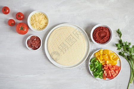 白色桌子上的新鲜面团比萨底和原料 顶层视图面包烘烤厨房餐厅面粉厨师烹饪糕点食物图片
