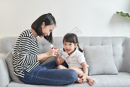 美丽的年轻母亲正在画指甲的清漆 给可爱的小女儿涂上美甲成人女孩乐趣父母修脚女性家庭妈妈孩子图片