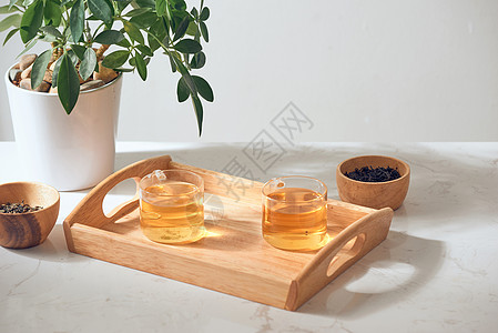 热茶在玻璃杯里 放在木质托盘上早餐植物液体草本植物草本健康杯子绿色橙子药品图片