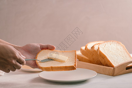 从高角角度拍摄的切白面包和黄油烹饪产品白色小吃食物盘子牛奶木板桌子早餐图片