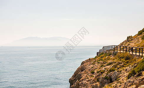 沿着海岸的木制长廊位于 Andalucja 的悬崖岩石上海滩天空小路途径人行道木头石头海洋踪迹假期图片