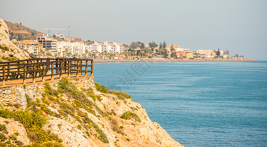 沿着海岸的木制长廊位于 Andalucja 的悬崖岩石上场景海滩小路远足石头灌木丛人行道途径天空旅行图片