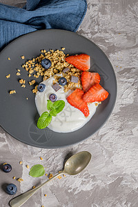 配有酸奶和颗粒的提取蓝莓和草莓奶油生物甜点勺子水果浆果饮食奶制品木头早餐图片