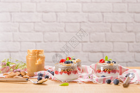 加燕麦和浆果的奇亚布丁奶昔勺子水果甜点牛奶玻璃小吃酸奶营养早餐图片