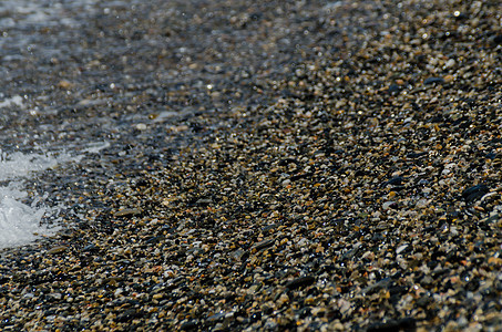 被海浪冲刷的卵石滩小而各种石头形成了海岸波浪花园鹅卵石墙纸支撑砂砾地面岩石蓝色材料图片