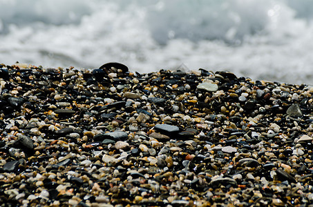 被海浪冲刷的卵石滩小而各种石头形成了海岸花园砂砾蓝色卵石材料鹅卵石岩石地面海洋波浪图片