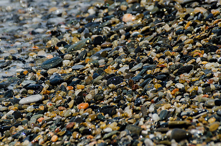 被海浪冲刷的卵石滩小而各种石头形成了海岸花园波浪支撑蓝色鹅卵石岩石砂砾地面海洋材料图片