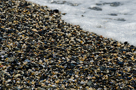 被海浪冲刷的卵石滩小而各种石头形成了海岸小路材料地面卵石岩石蓝色海洋支撑墙纸砂砾图片