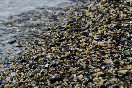 被海浪冲刷的卵石滩小而各种石头形成了海岸地面卵石砂砾岩石鹅卵石支撑海洋蓝色墙纸波浪图片