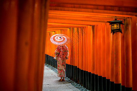 在Yukata的日本女孩 在神社带着红色伞图片