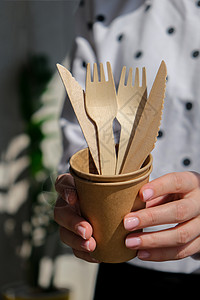 女性手握着木质叉子和带有板块的纸杯 生态友好型可支配餐具 用于快餐 餐馆 外卖 野餐生活方式健康生活用具家庭工艺回收生物浪费纸板图片