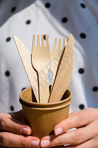 女性手握着木质叉子和带有板块的纸杯 生态友好型可支配餐具 用于快餐 餐馆 外卖 野餐塑料用具包装回收盘子纸板生物环境浪费家庭图片