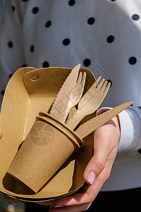 女性手握着木质叉子和带有板块的纸杯 生态友好型可支配餐具 用于快餐 餐馆 外卖 野餐包装家庭生活方式女士餐具工艺用具回收纸板杯子图片