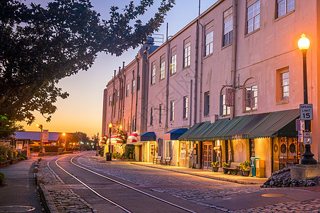 佐治亚州萨凡纳市中心河街的商店和餐馆日落城市景观铁路天际建筑学酒吧河街场景风景图片