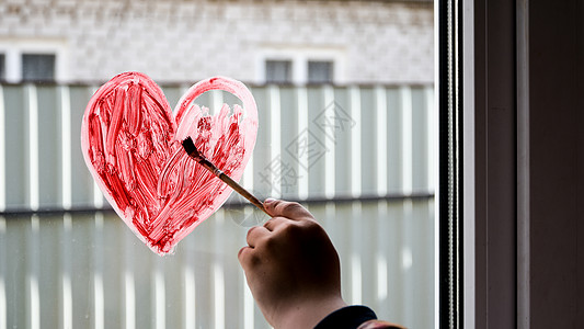 一个女孩的手 在窗户上画着粉刷红心 复制文字空间 呆在家里孩子们刷子绘画玻璃彩虹艺术儿童育儿爱心乐趣图片