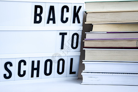 以白色背景的文字和书籍返回学校的灯盒木板幼儿园打印学生桌子学习团体课堂大学黑板图片