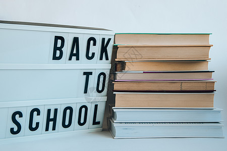 以白色背景的文字和书籍返回学校的灯盒班级幼儿园图书学习打印学生教科书木板绘画课堂图片