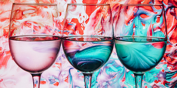 三个酒杯排成一排 后面有彩色光绘红白玫瑰红酒banne的三个酒杯套装玻璃装饰品饮料几何学线条条纹折射配置艺术橙子图片