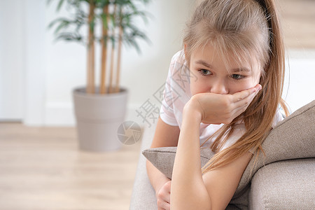 年幼的悲伤少女坐在沙发上童年头发白色女士长椅青少年思维女孩冒充房间图片