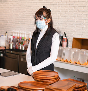 咖啡店老板佩戴外科手术面具 有自信的女商务人士图片
