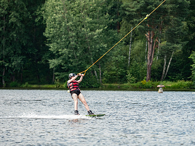 唤醒湖边的登机男孩 在模糊背景的森林里动机挑战娱乐短裤生活方式技巧锻炼体力假期救生衣图片
