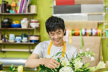 鲜花店老板微笑的肖像在工作 小生意花艺花束店铺零售职业商业园艺植物兰花男人图片