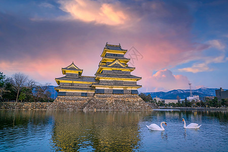 松本城及其在日本长野县松本市的倒影寺庙日落地标游客历史性城堡旅游遗产城市天空图片