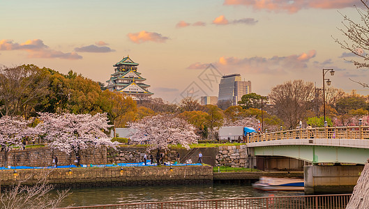 日本大阪樱花樱花季节在大阪城堡的暮光遗产地标文化吸引力天际历史日落旅游花园背景