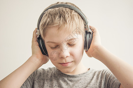 男孩耳机享受音乐 手放在耳机上图片