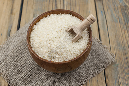 大米碗和勺子放在老木地板上棕色粮食农业烹饪营养食物美食白色文化午餐图片