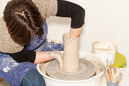 女性波特 在波特的轮子上制造一个土罐图片