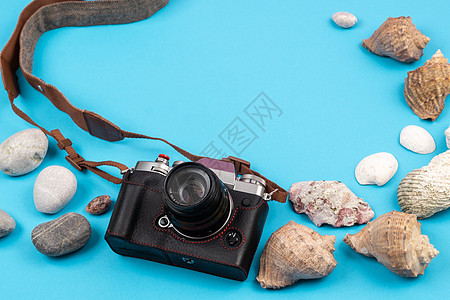 蓝色背景上的相机和贝壳 旅行的背景夏令照片旅游石头假期配件摄影师绳索框架说谎图片