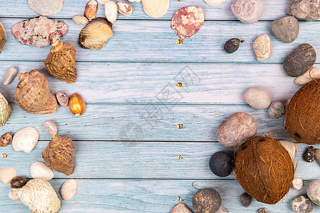 蓝色木质背景上的椰子岩石和贝壳 将它们海洋化旅游海洋旅行地方主题季节配件海滩框架照片图片