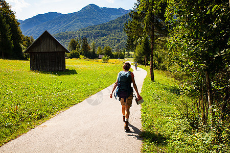 在斯洛文尼亚乡村带背背包徒步旅行的年轻女子小路女孩国家贸易树木山脉旅游农村信仰女士图片