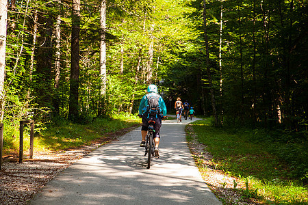 骑自行车骑自行车的骑摩托车者骑着乡村田径娱乐家庭小路运动活动车道树木森林闲暇竞赛图片