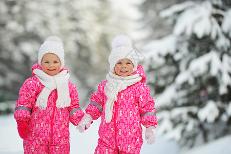 两个穿红西装的小双胞女 站在寒雪的冬季森林里双胞胎姐妹白帽子红色新年朋友们婴儿兄弟公园孩子们图片