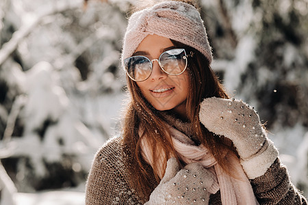 一个穿着毛衣和眼镜的女孩 冬天在一个雪覆盖的森林里女性头发成人新年季节手套快乐微笑女士雪堆图片